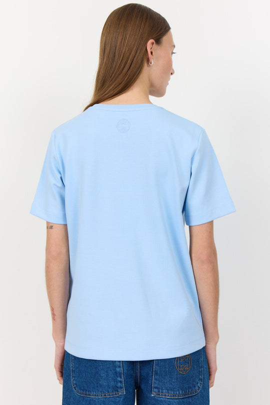 Leveté Room Kis 1 Tee – lys blå T-shirt i 100% økologisk bomuld. Klassisk rund hals, korte ærmer og afslappet pasform.
