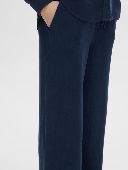 Selected Femme Viva-Gulia HW Long Sun Pant i hørblanding med høj elastisk talje, justerbar snor, skårede sidelommer og loose fit. Perfekte forår- og sommerbukser.