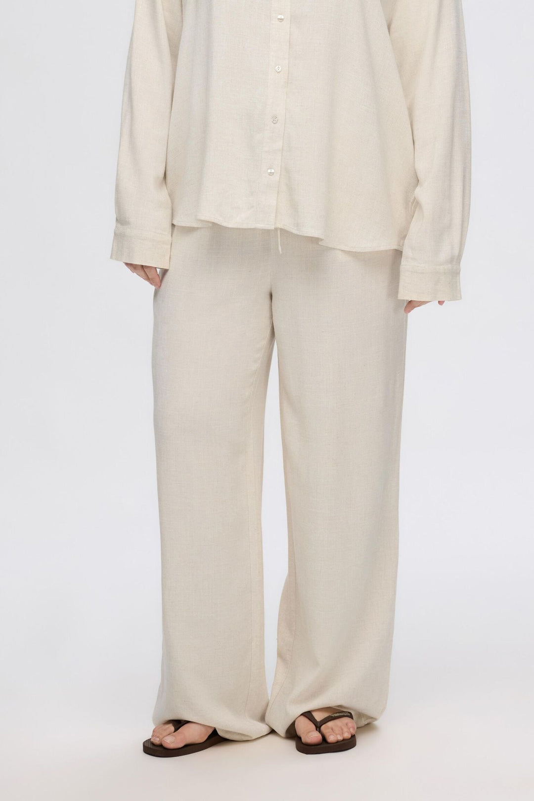 Selected Femme Viva-Gulia HW Long Sun Pant i hørblanding med høj elastisk talje, justerbar snor, skårede sidelommer og loose fit. Perfekte forår- og sommerbukser.