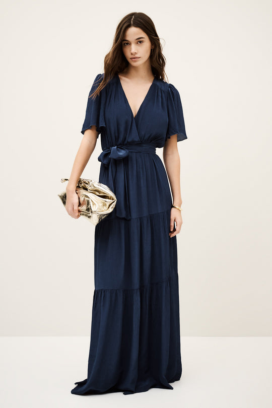 ba&sh Natalia Dress i mørk blå – elegant plisseret maxi kjole i dark blue med wrap-neck og bælte i taljen. Perfekt til sommerens events.