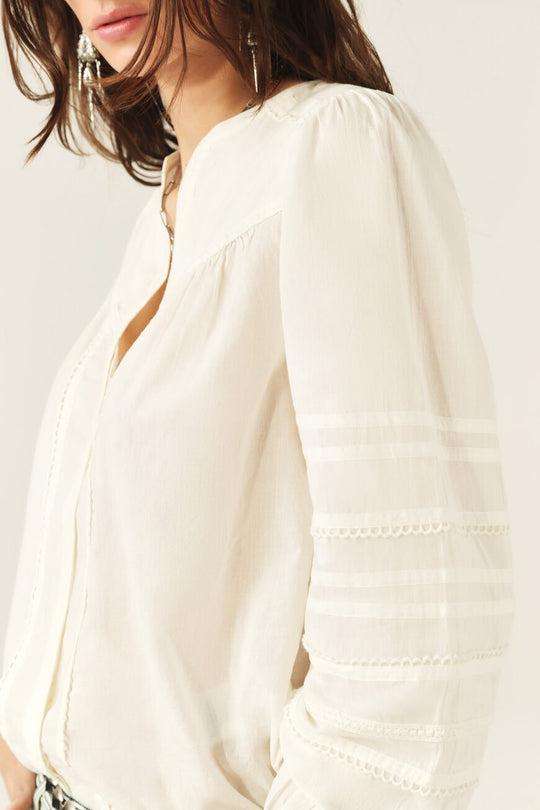 ba&sh Yilla Bluse – V-hals, skjult knaplukning og plisserede detaljer. 100% økologisk bomuld.