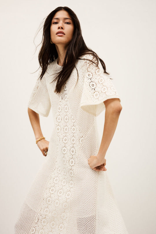 ba&sh Moody kjole i ecru med blondeindsatser, let udvidede ærmer og udstillet skørt. Foret med underkjole i viskose-georgette. 100 % bomuld.