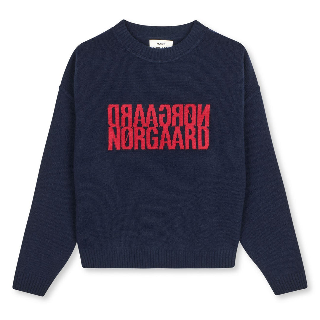 Mads Nørgaard Yota Knit Tilona Sweater i Parisian Night. Boxy strik med spejlvendt logo, fremstillet i uld og genanvendte materialer. Stilfuld og bæredygtig.