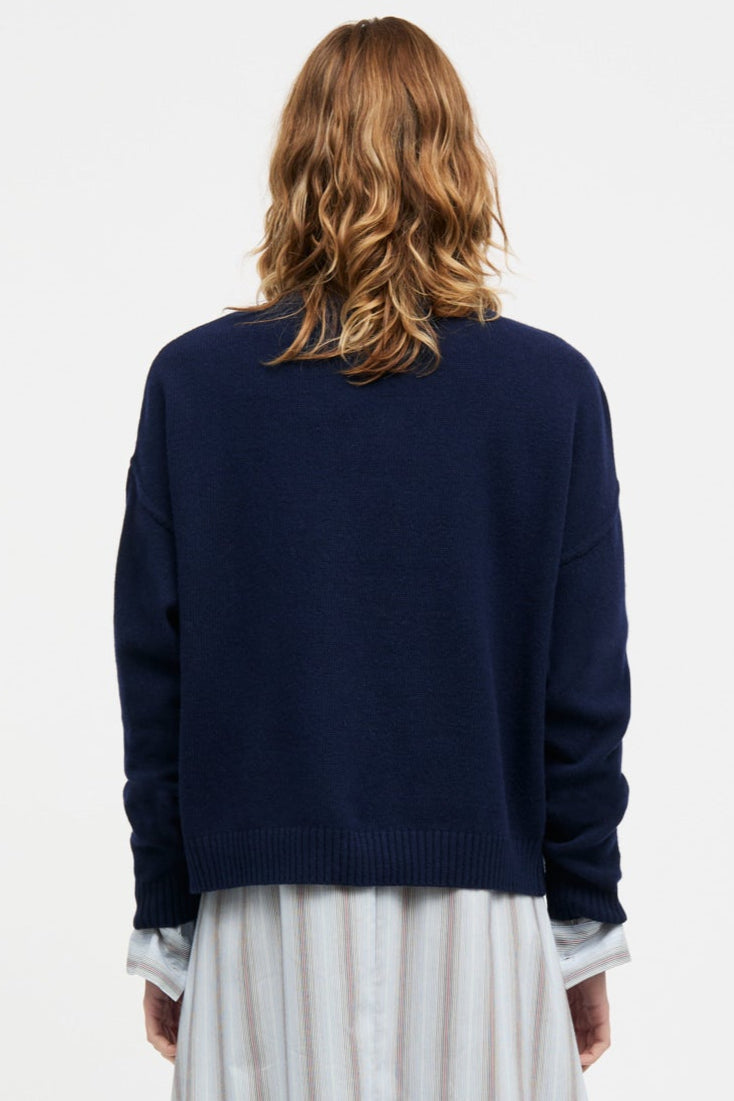 Mads Nørgaard Yota Knit Tilona Sweater i Parisian Night. Boxy strik med spejlvendt logo, fremstillet i uld og genanvendte materialer. Stilfuld og bæredygtig.