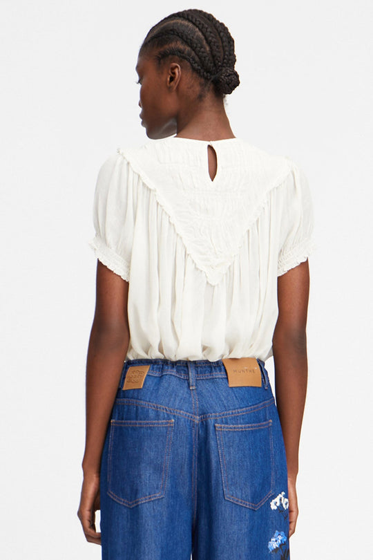 Perilla Top fra Munthe – elegant ivory-skjorte i bæredygtig viscose med smukke flæsedetaljer. Perfekt til både hverdag og fest.