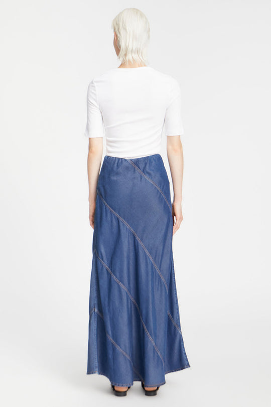 Munthe Parson Skirt i indigo – en lang denim nederdel med smukke skrå syninger og elastik i taljen. Let og bæredygtig i 100% TENCEL™.