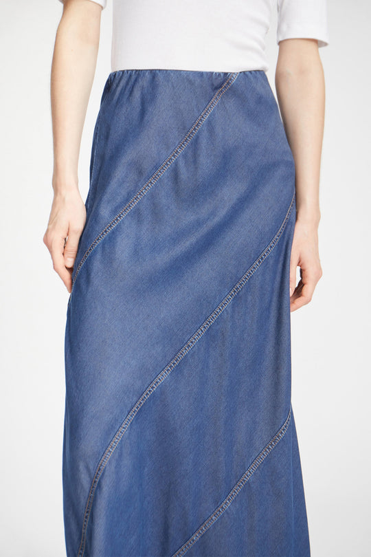 Munthe Parson Skirt i indigo – en lang denim nederdel med smukke skrå syninger og elastik i taljen. Let og bæredygtig i 100% TENCEL™.