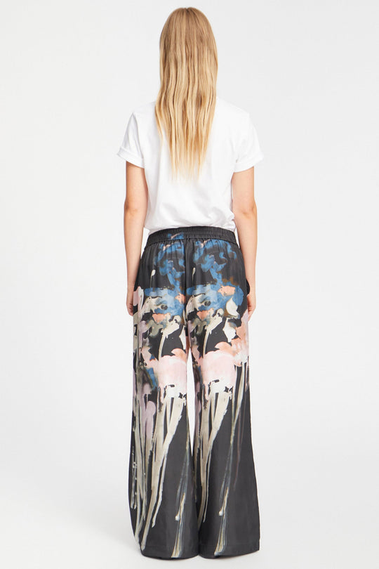 Munthe Arum Silk Pants i sort med et kunstprint – elegante silkebukser med løs pasform, elastik i taljen og sidelommer.