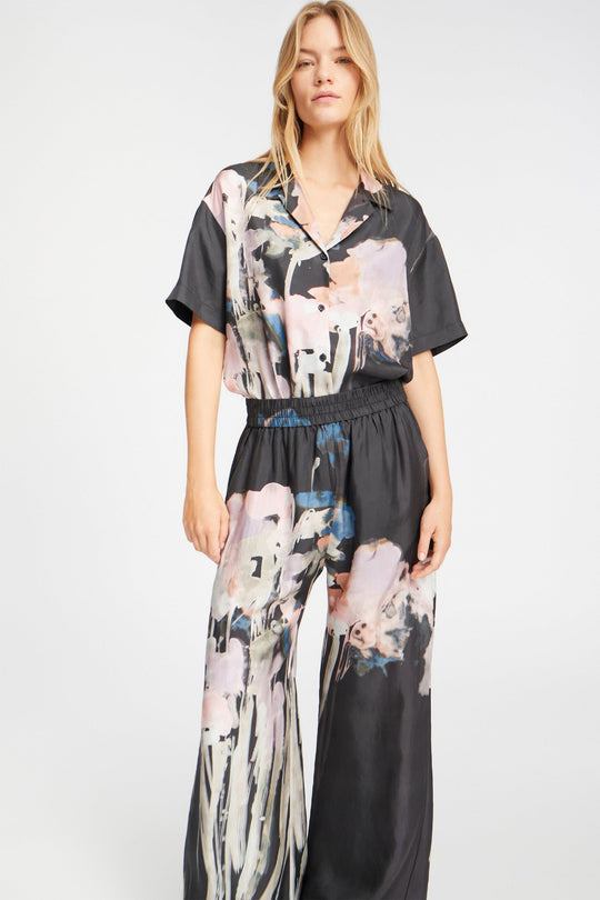 Munthe Arum Silk Pants i sort med et kunstprint – elegante silkebukser med løs pasform, elastik i taljen og sidelommer.