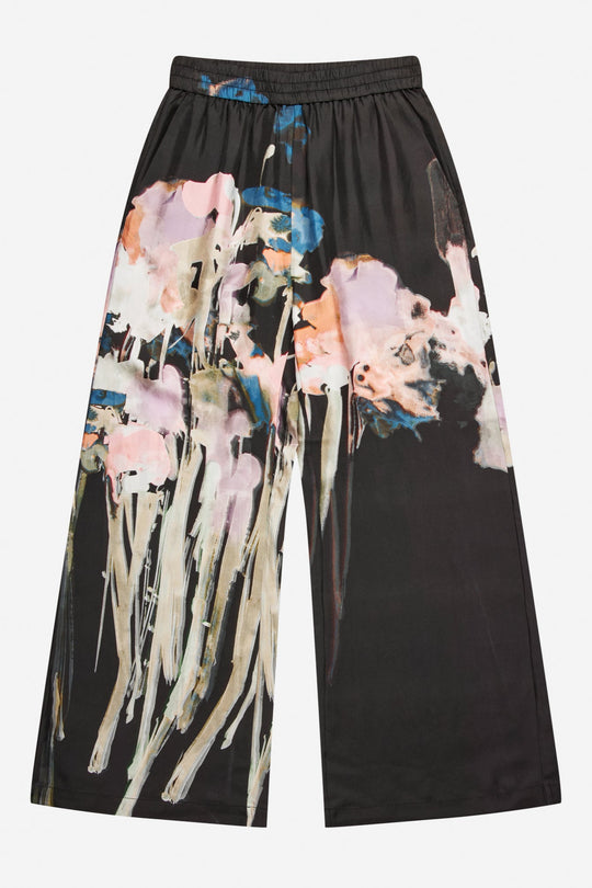 Munthe Arum Silk Pants i sort med et kunstprint – elegante silkebukser med løs pasform, elastik i taljen og sidelommer.