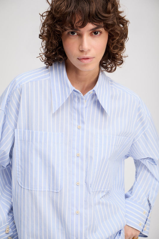 Munthe Lynne oversize skjorte i lyseblå med striber, imiterede hornknapper og brede manchetter. 100 % økologisk bomuld.