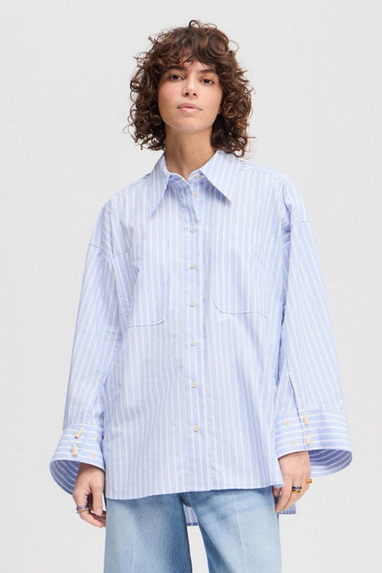 Munthe Lynne oversize skjorte i lyseblå med striber, imiterede hornknapper og brede manchetter. 100 % økologisk bomuld.
