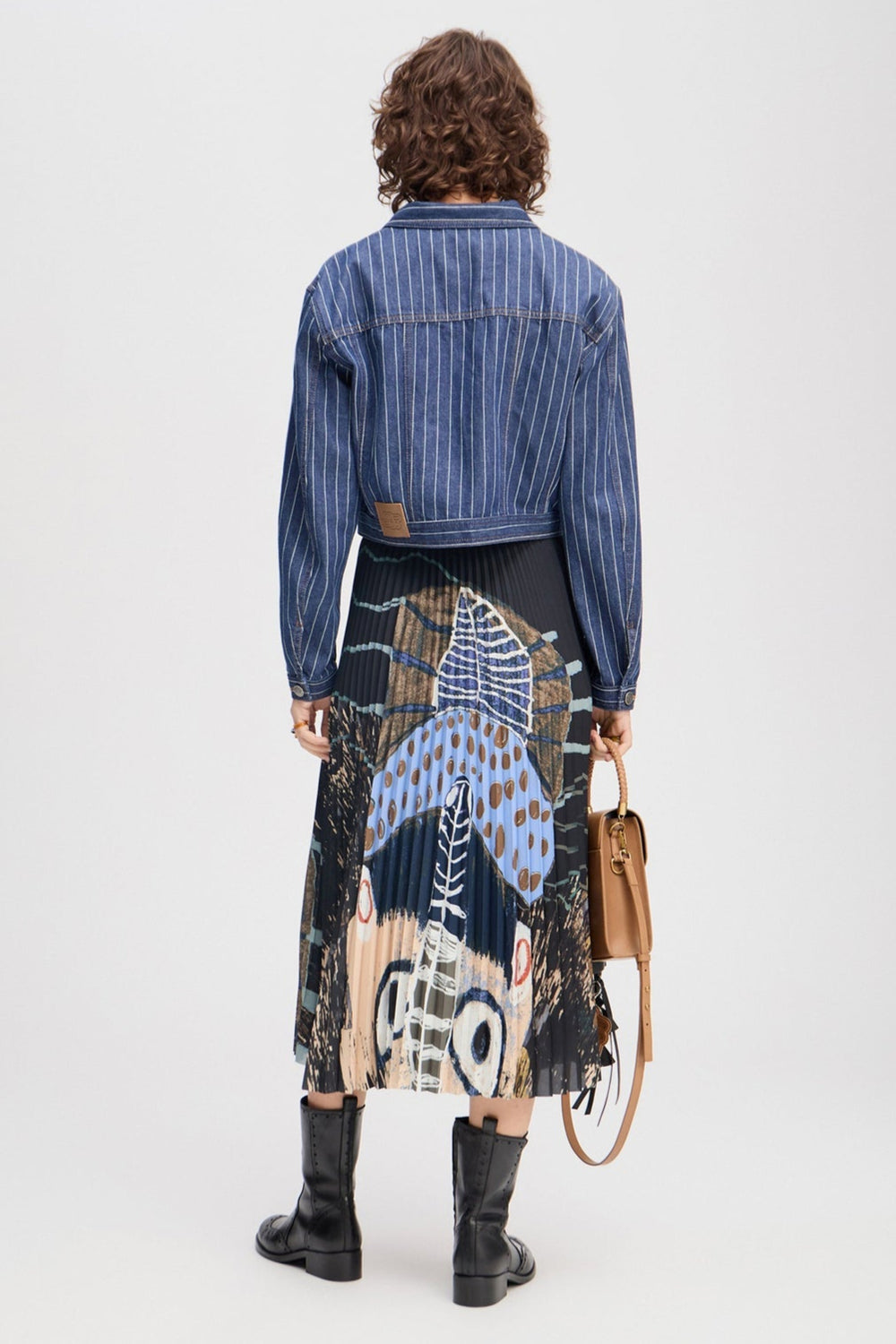 Munthe Charming plisseret nederdel i sort med kunstprint, midi-længde og elastik i taljen. Lavet i genanvendt polyesterblanding.