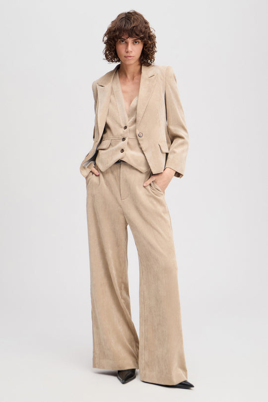 Munthe Lelouis lattefarvede fløjlsbukser med brede ben, sidelommer og bæltestropper. Delvist lavet i genanvendt materiale.