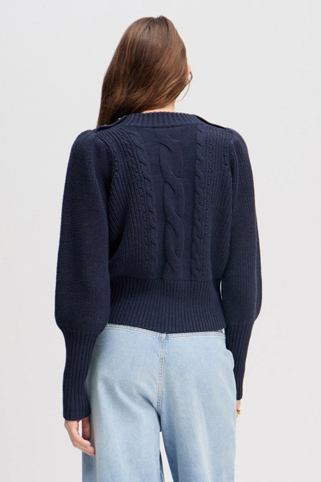 Munthe Lysta navy kabelstrik med brede ærmer, høj ribkant og knaplukning ved halsen. Blød blanding af bomuld, akryl og uld.
