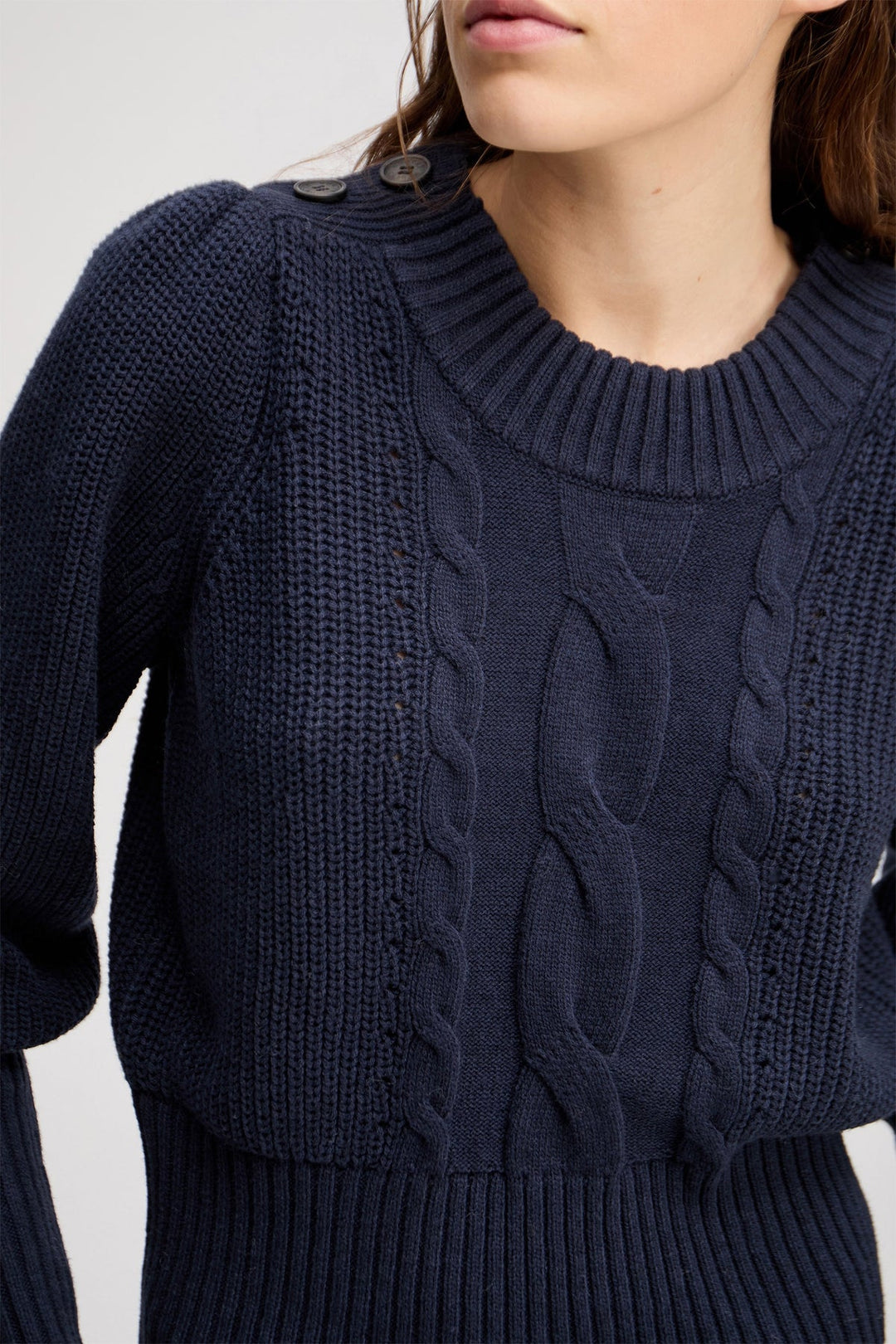Munthe Lysta navy kabelstrik med brede ærmer, høj ribkant og knaplukning ved halsen. Blød blanding af bomuld, akryl og uld.