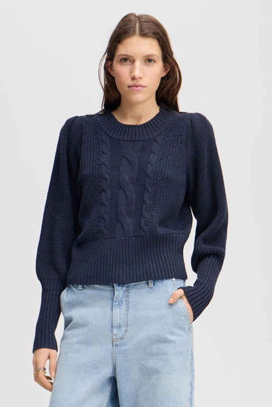 Munthe Lysta navy kabelstrik med brede ærmer, høj ribkant og knaplukning ved halsen. Blød blanding af bomuld, akryl og uld.