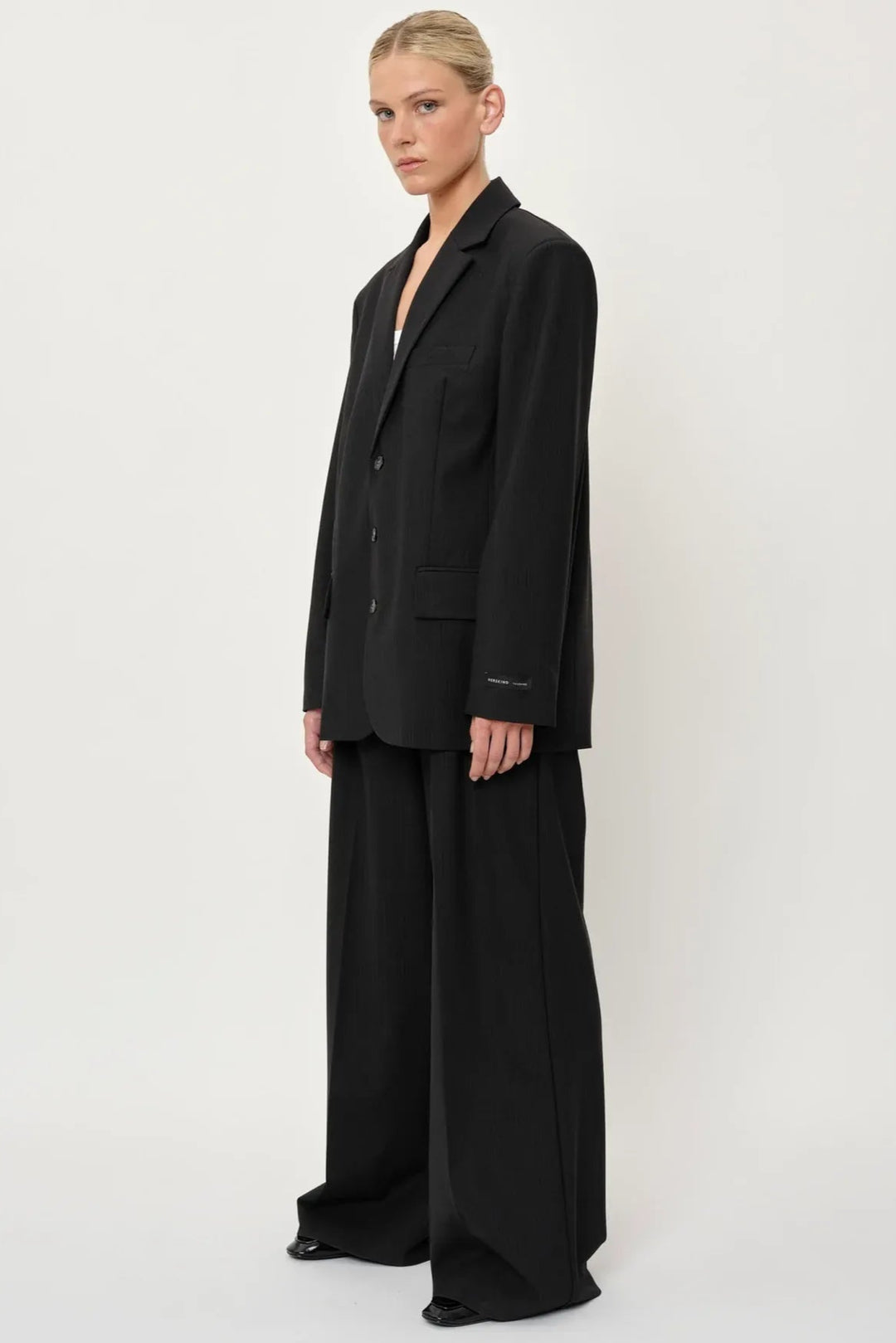 Herskind Kelly Pants – klassiske mørkegrå pinstripe bukser med mid-waist, læg og pressefold.