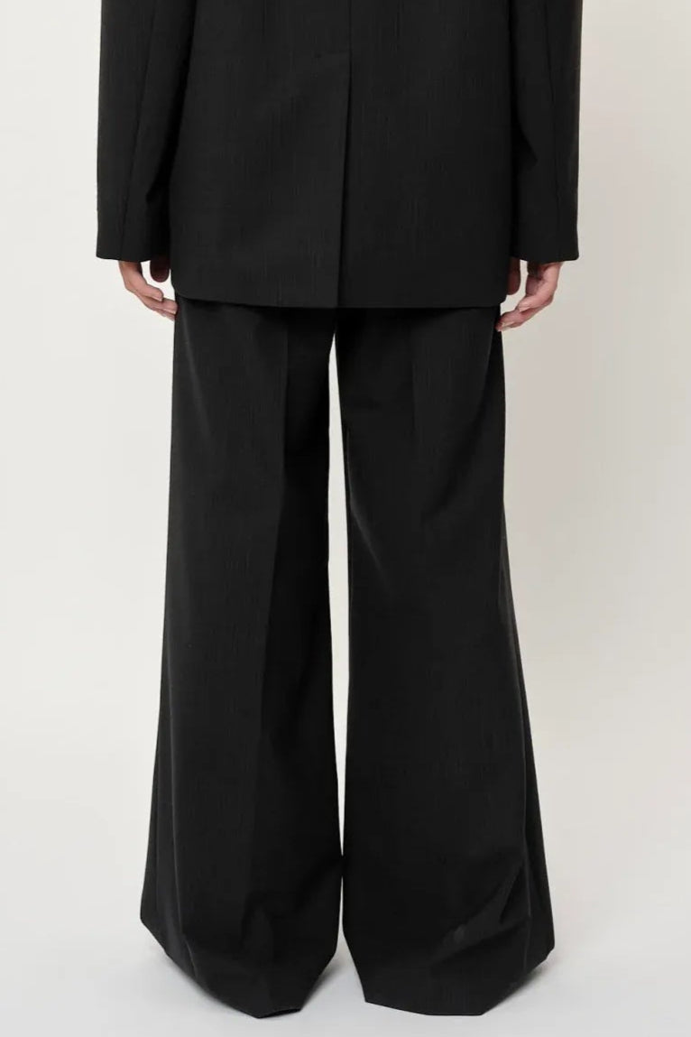 Herskind Kelly Pants – klassiske mørkegrå pinstripe bukser med mid-waist, læg og pressefold.