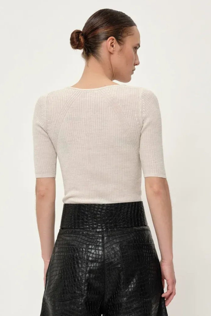 Herskind Agnes Knit Blouse – eksklusiv ribstrikket bluse i 100% merinould med halvlange ærmer og knaplukning. Blød, elegant og tidløs.