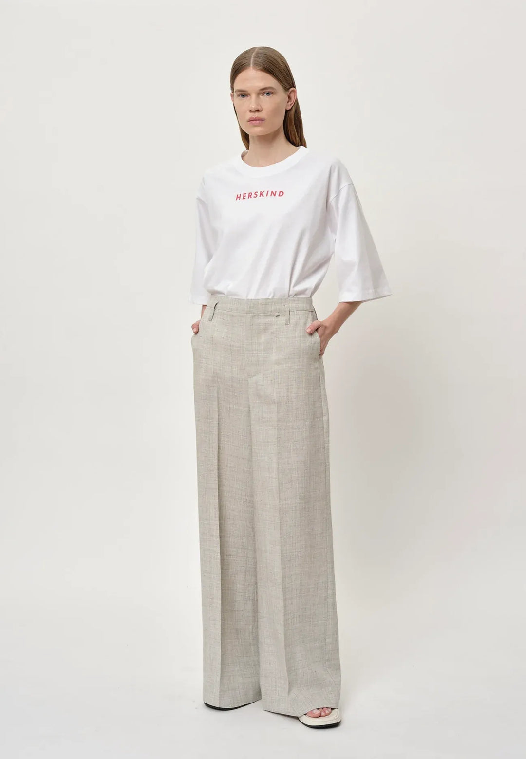 Herskind Poppy Pants i sand – klassiske bukser med mid-waisted pasform, skarpe linjer og store lommer. Fremstillet i italiensk stof. Perfekte til et skræddersyet look. Cassandra.dk