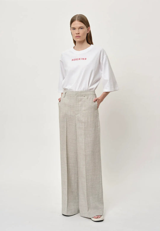 Herskind Poppy Pants i sand – klassiske bukser med mid-waisted pasform, skarpe linjer og store lommer. Fremstillet i italiensk stof. Perfekte til et skræddersyet look. Cassandra.dk