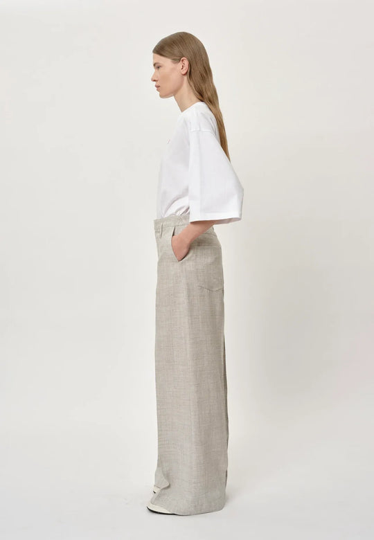 Herskind Poppy Pants i sand – klassiske bukser med mid-waisted pasform, skarpe linjer og store lommer. Fremstillet i italiensk stof. Perfekte til et skræddersyet look. Cassandra.dk