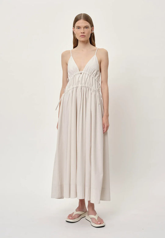 Herskind Miranda Dress i creme pinstripe – lang V-hals kjole med horisontale cutlines og justerbar snøre.