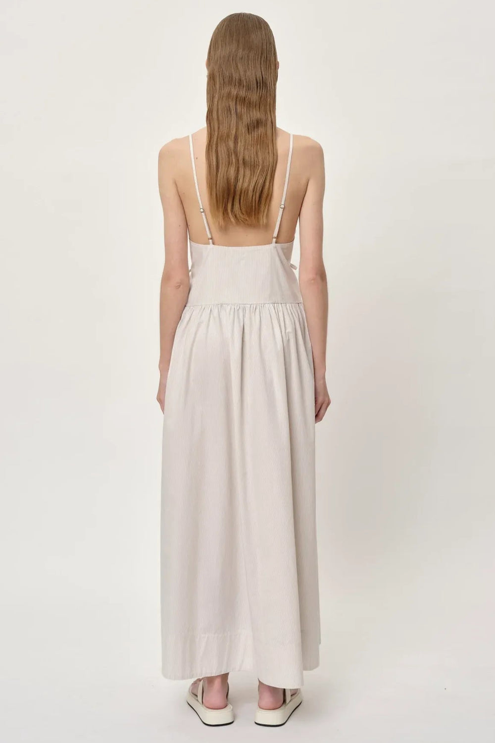 Herskind Miranda Dress i creme pinstripe – lang V-hals kjole med horisontale cutlines og justerbar snøre.
