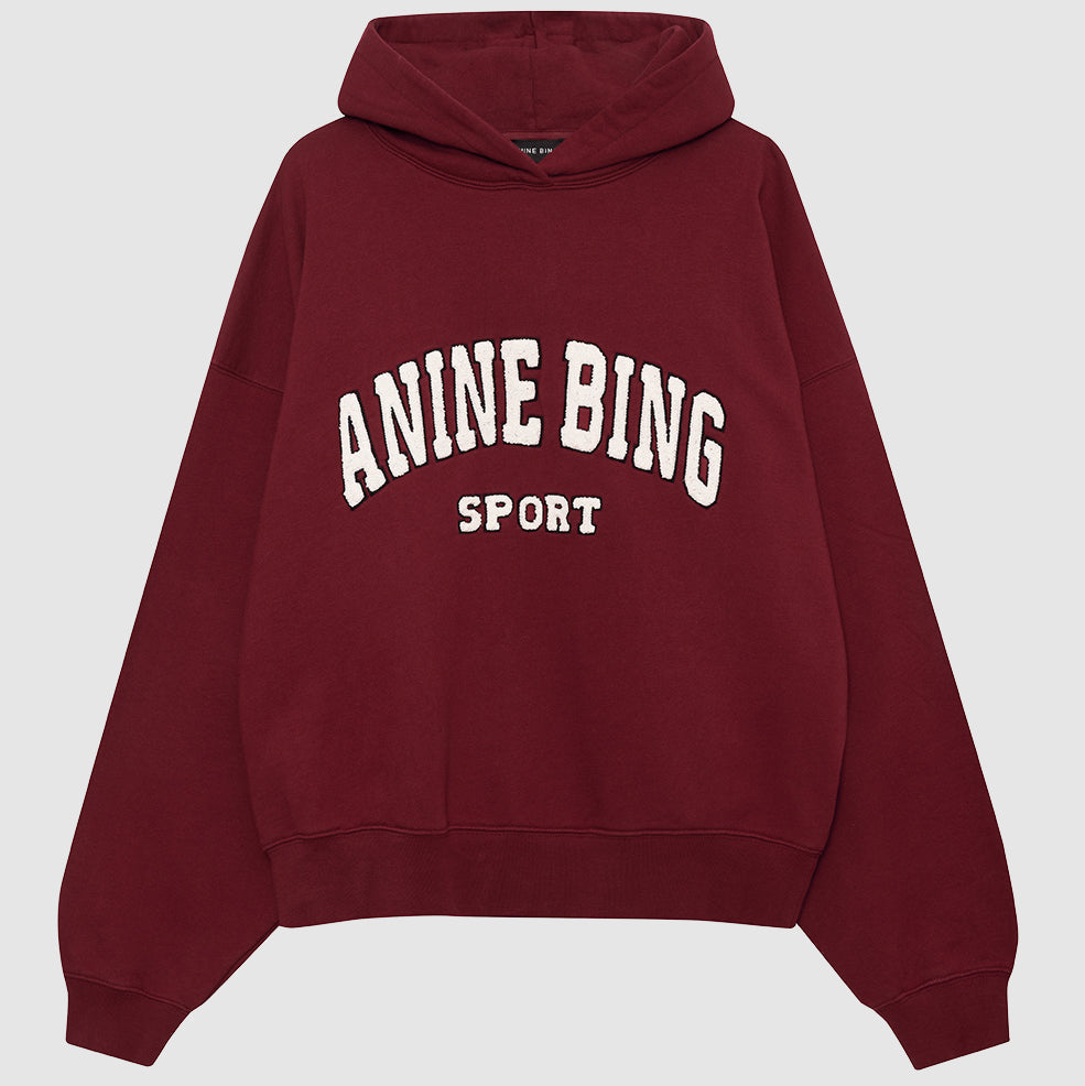 Anine Bing Alec Hoodie Sport i cabernet rød. Chenille patch i ivori og sort broderi. Let oversized pasform med kortere længde for en afslappet, sporty stil.