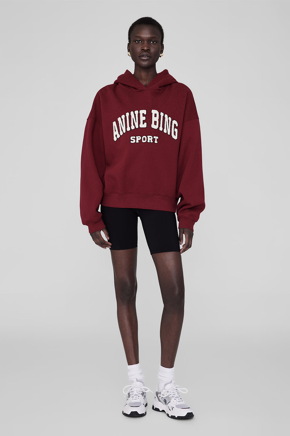 Anine Bing Alec Hoodie Sport i cabernet rød. Chenille patch i ivori og sort broderi. Let oversized pasform med kortere længde for en afslappet, sporty stil.