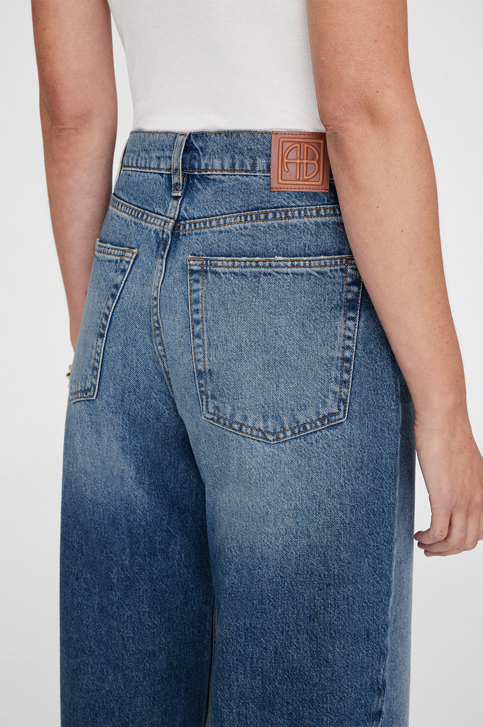 Anine Bing Brie Jean – højtaljede wide-leg jeans i 100% bomuldsdenim med twisted søm-detaljer og afslappet pasform.