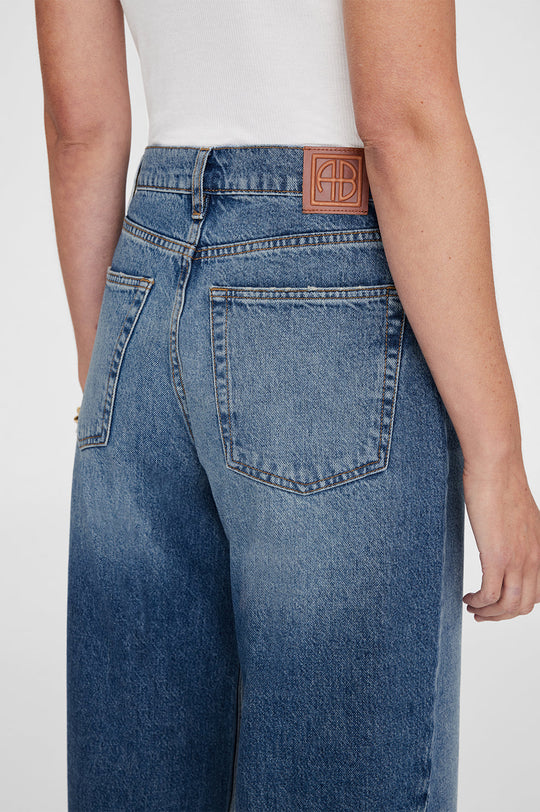 Anine Bing Brie Jean – højtaljede wide-leg jeans i 100% bomuldsdenim med twisted søm-detaljer og afslappet pasform.