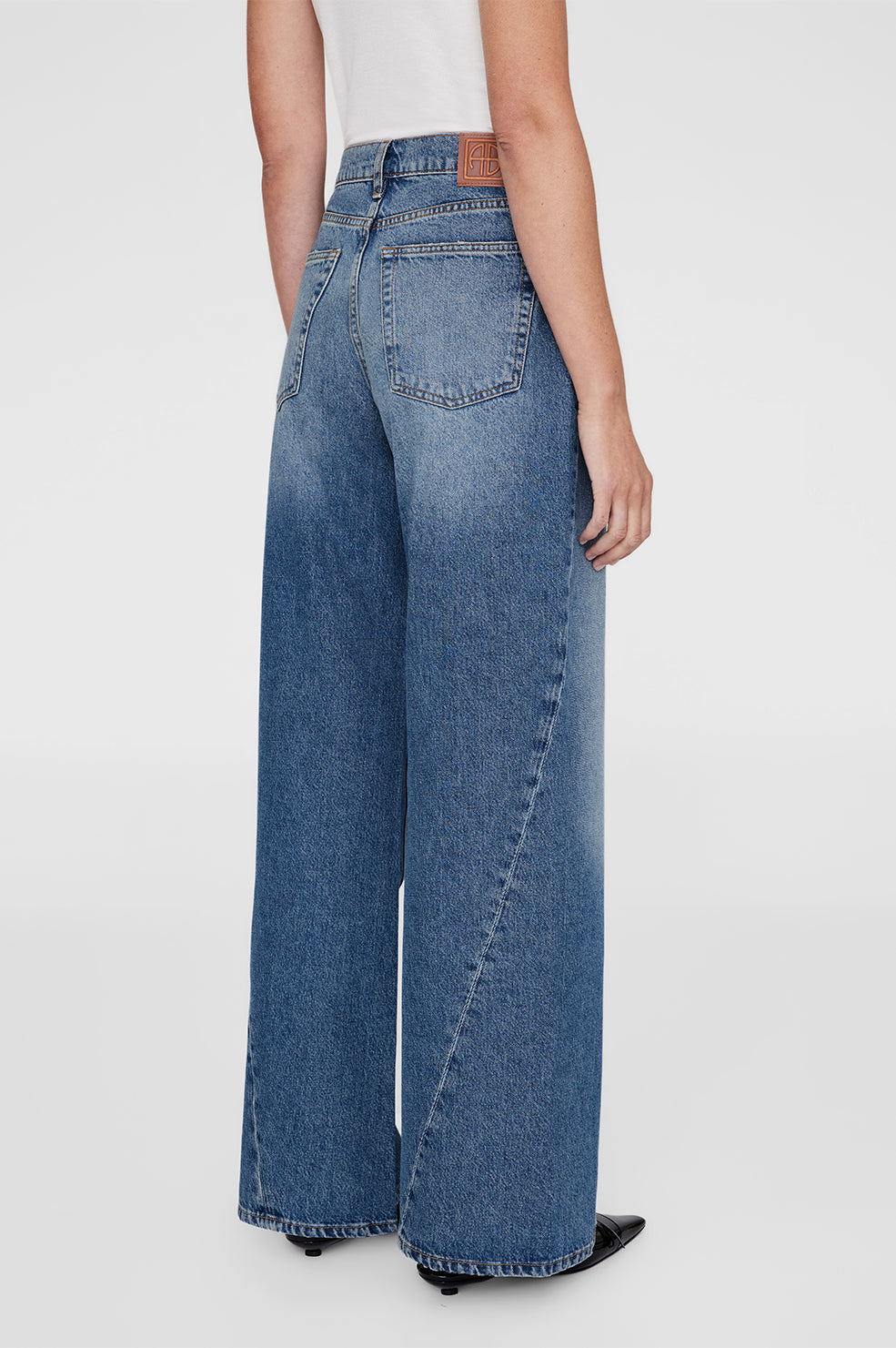 Anine Bing Brie Jean – højtaljede wide-leg jeans i 100% bomuldsdenim med twisted søm-detaljer og afslappet pasform.