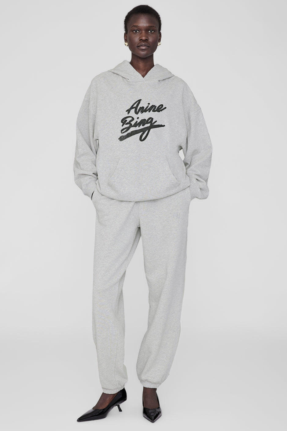 Anine Bing Harvey Sweatshirt i heather grey. Oversized hoodie med signaturgrafik, vintage-look og kængurulomme. Komfortabel og stilfuld på én gang.