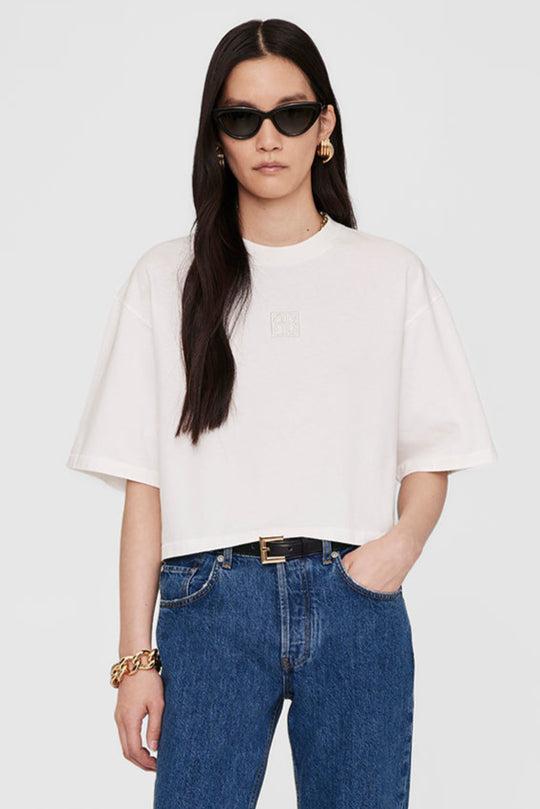 Anine Bing Myers Cropped Tee – cropped oversized T-shirt i 100% bomuld med broderet monogram. Minimalistisk design i ivory, perfekt til casual chic looks.