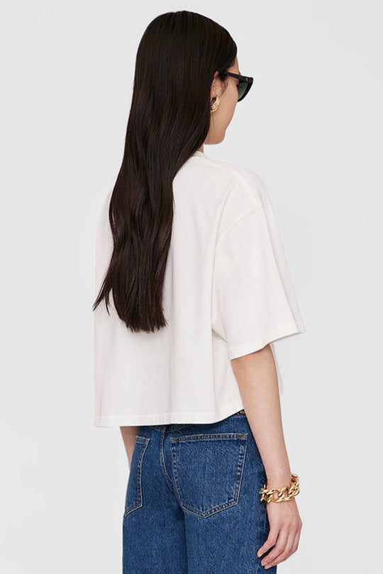 Anine Bing Myers Cropped Tee – cropped oversized T-shirt i 100% bomuld med broderet monogram. Minimalistisk design i ivory, perfekt til casual chic looks.