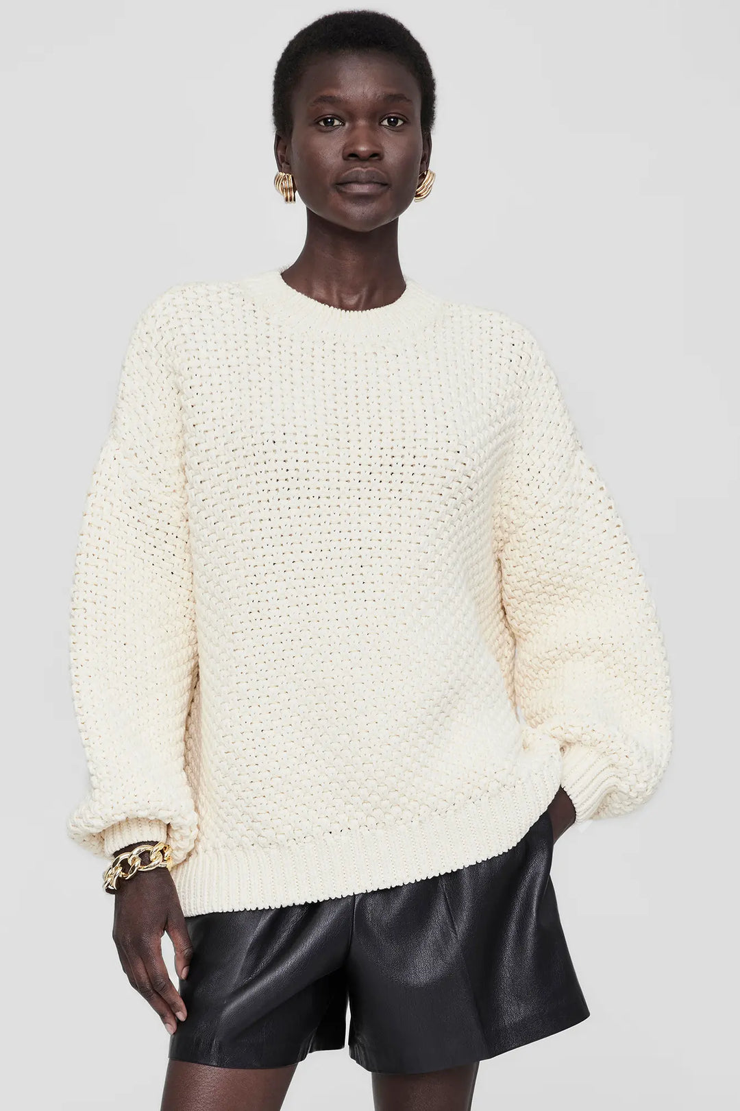 Anine Bing Sydney Crew Sweater – løstsiddende strik i ivory med grov hulmønstret perlestrik. Eksklusivt design i bomuldsblanding.