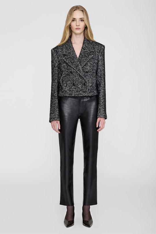Anine Bing Vienna Blazer i sort og hvid tweed med herringbone-mønster. Cropped snit, dobbeltradet lukning og sofistikerede detaljer for et elegant look.