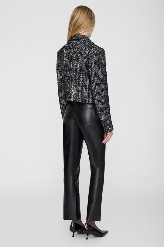 Anine Bing Vienna Blazer i sort og hvid tweed med herringbone-mønster. Cropped snit, dobbeltradet lukning og sofistikerede detaljer for et elegant look.