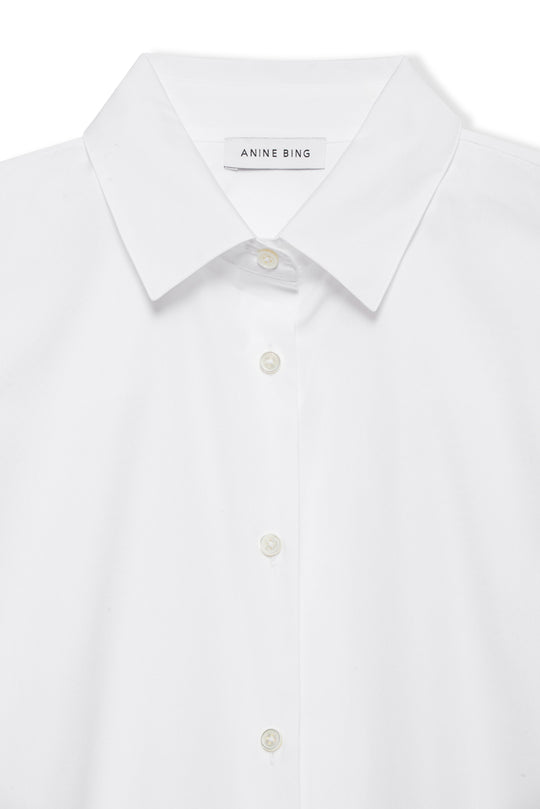 Anine Bing Essie Shirt – hvid tailored skjorte i 100% bomuldspoplin med perlemorsknapper og luksuriøse detaljer. Tidløs og elegant.