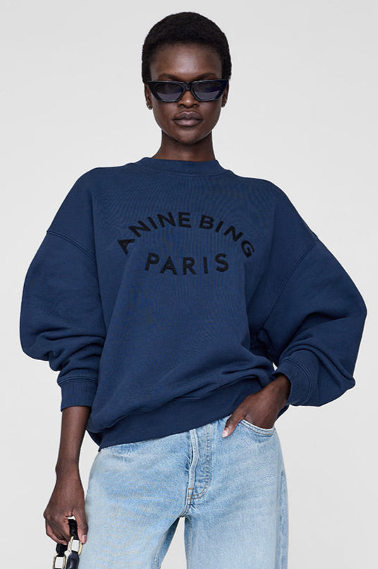 Anine Bing Jaci Paris sweatshirt i washed navy med oversized pasform, vintage-inspireret filtpatch og 100 % bomuldsfleece. Eksklusivt og komfortabelt design.
