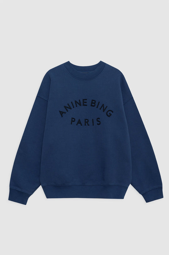 Anine Bing Jaci Paris sweatshirt i washed navy med oversized pasform, vintage-inspireret filtpatch og 100 % bomuldsfleece. Eksklusivt og komfortabelt design.