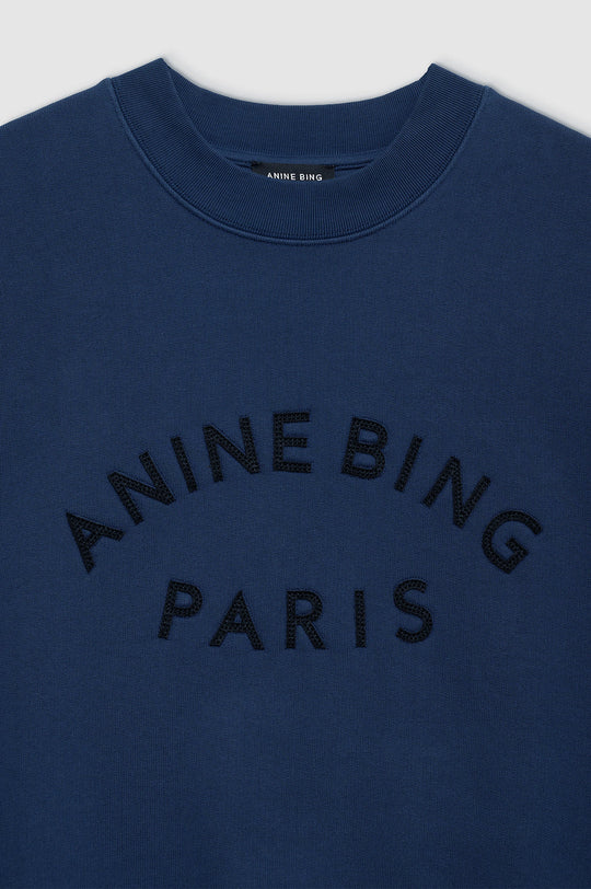Anine Bing Jaci Paris sweatshirt i washed navy med oversized pasform, vintage-inspireret filtpatch og 100 % bomuldsfleece. Eksklusivt og komfortabelt design.