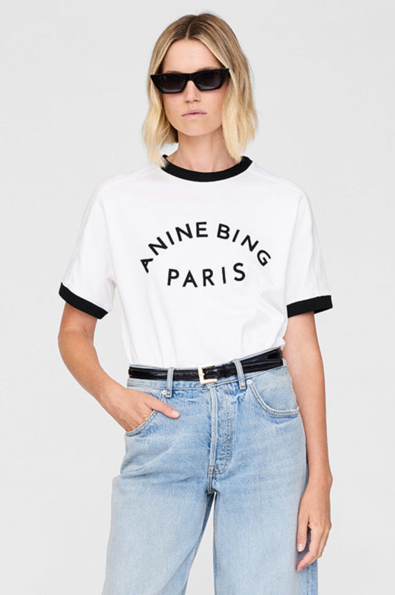 Anine Bing Jaylin Tee Paris i ivory med sorte kontrastdetaljer, boxy fit og filtpatch. Lavet i kraftig 100 % bomuldsjersey – tidløs og cool.
