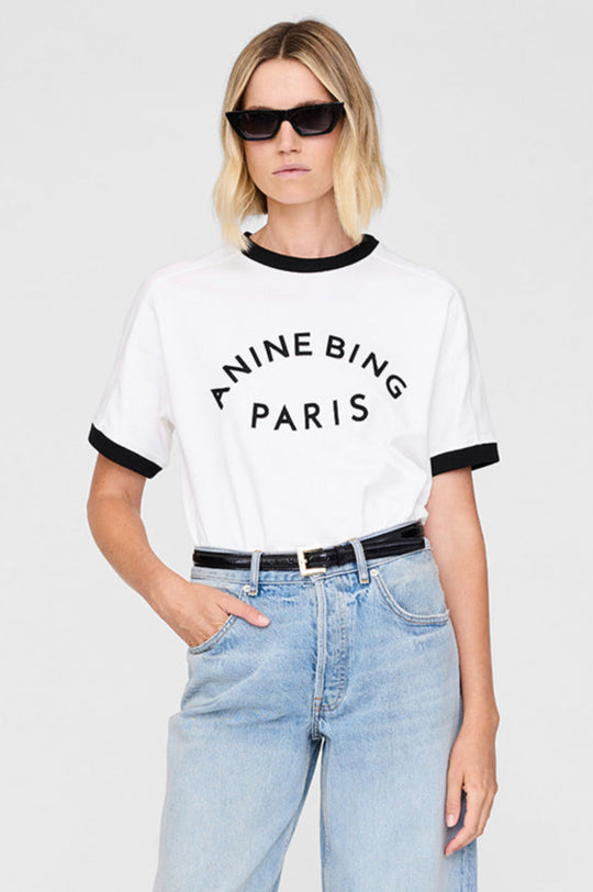 Anine Bing Jaylin Tee Paris i ivory med sorte kontrastdetaljer, boxy fit og filtpatch. Lavet i kraftig 100 % bomuldsjersey – tidløs og cool.