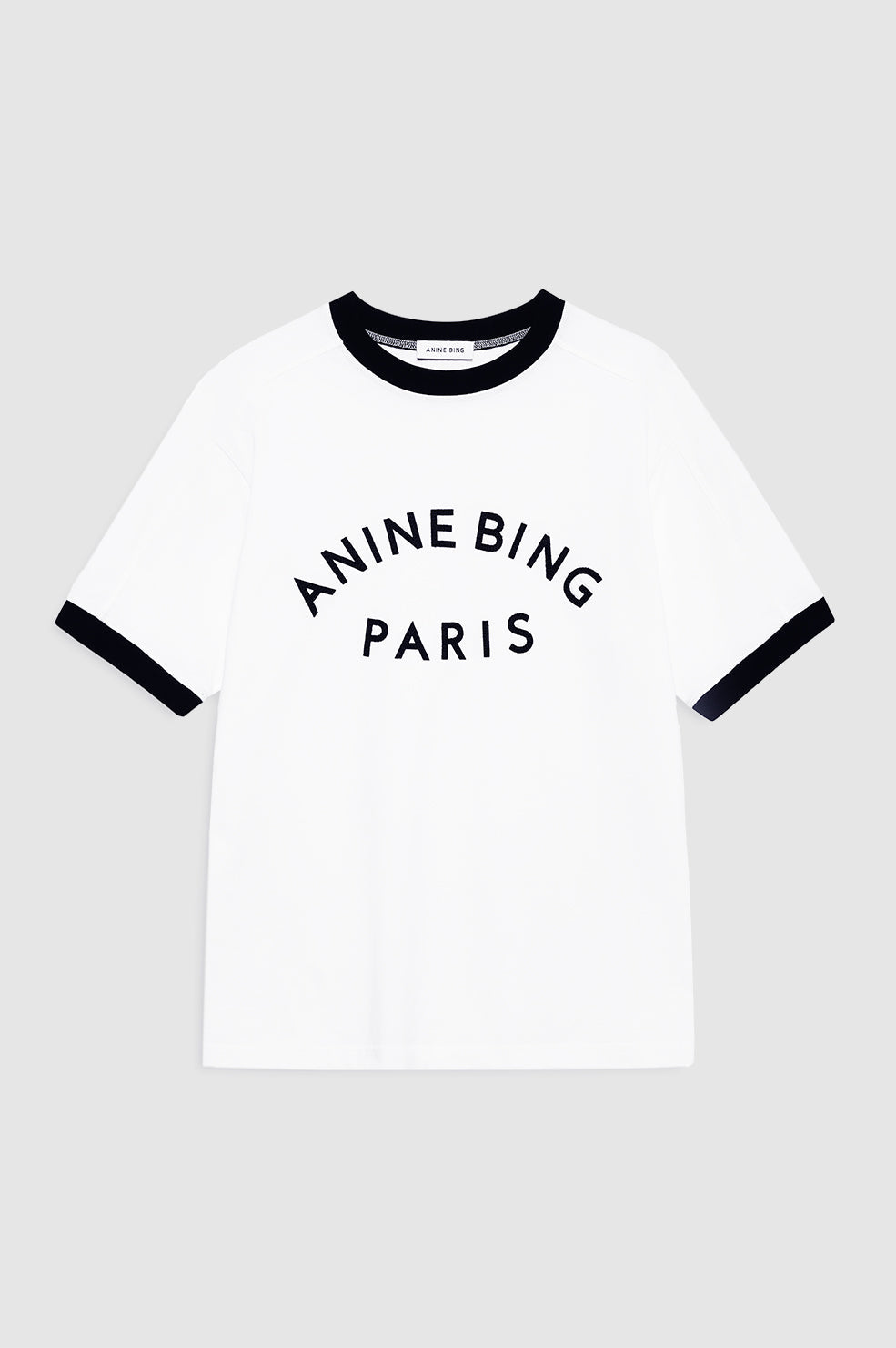 Anine Bing Jaylin Tee Paris i ivory med sorte kontrastdetaljer, boxy fit og filtpatch. Lavet i kraftig 100 % bomuldsjersey – tidløs og cool.