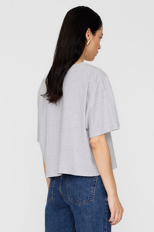 Johnny Cropped Tee fra Anine Bing – grå T-shirt med vintage LA-print og rå detaljer. Cropped pasform og 100% bomuld.