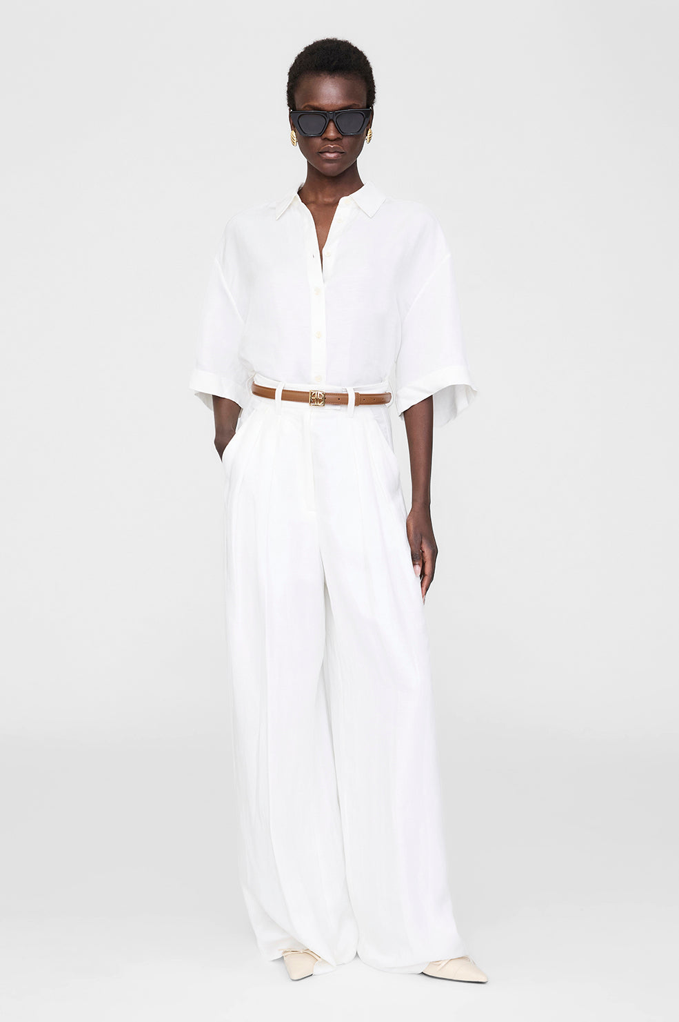 Anine Bing Monogram Belt i cognac – klassisk læderbælte med guld logospænde og justerbar lukning.