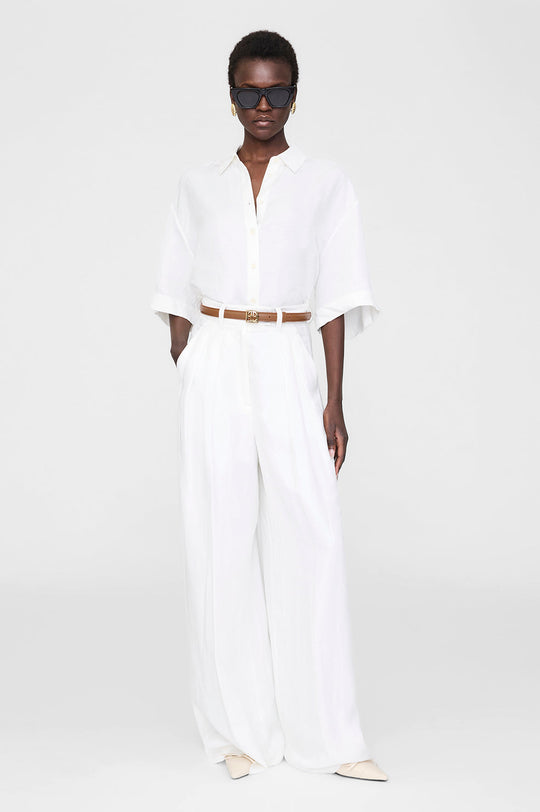 Anine Bing Monogram Belt i cognac – klassisk læderbælte med guld logospænde og justerbar lukning.